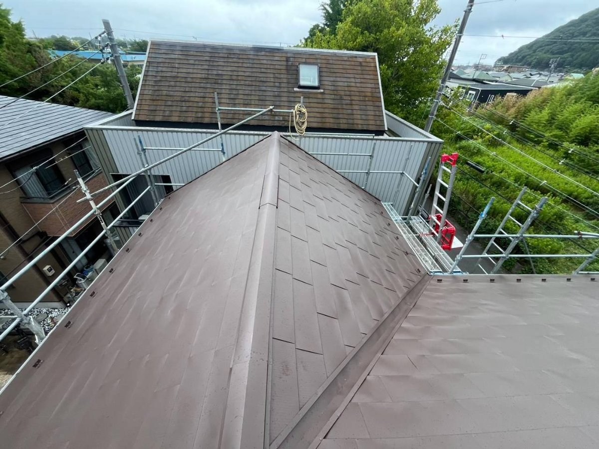 棟板金まわりの施工です。屋根の頂点に下地と板金を取り付け、接合部をふさぎます。風で飛ばないよう固定する部分です。屋根の頂上の板金は、風と熱で浮きや錆が出やすい部分です。（7月28日）