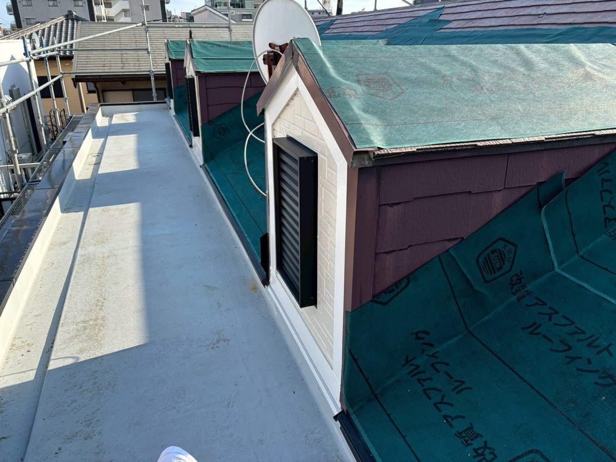 防水シート貼りです。屋根カバー工法では、既存の屋根の上に防水シートを敷き詰めます。雨を実際に止めているのはこの層です。(3月16日)